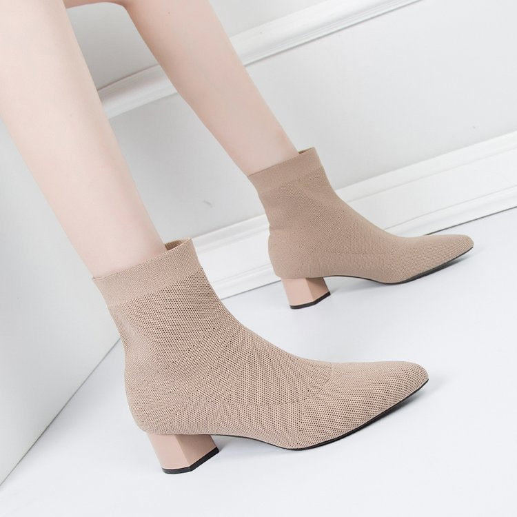 Woman wearing khaki pointed-toe sock ankle boots