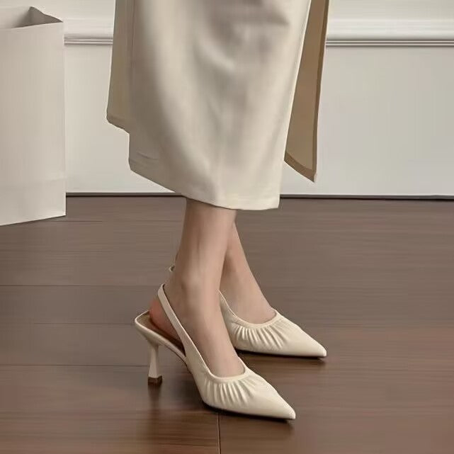 Beige ruched pointed slingbacks worn with a cream midi skirt, front view