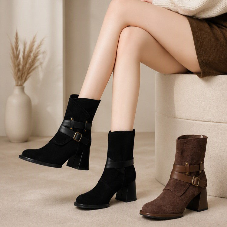 Woman seated wearing black buckle-strap suede ankle boots beside a brown pair