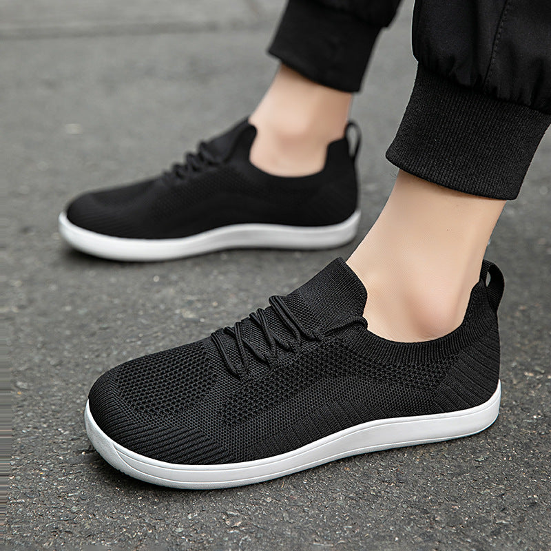 Man wearing black knit lace-up sneakers with white soles
