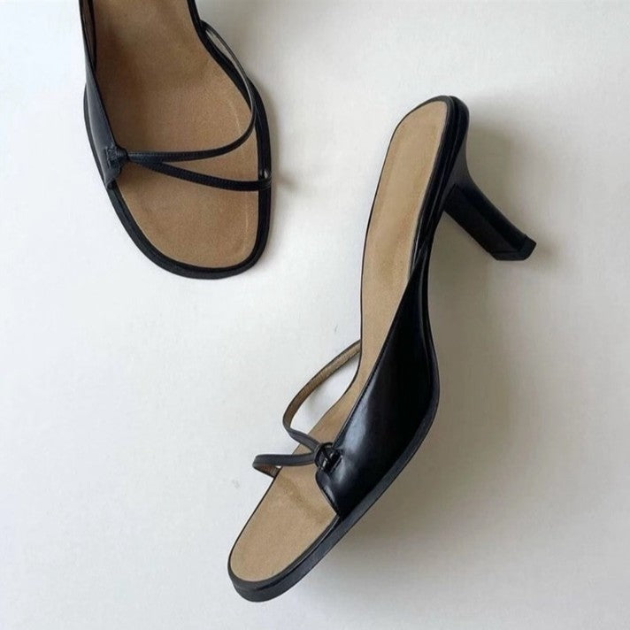 Black strappy square-toe heeled sandals showing the slim heel