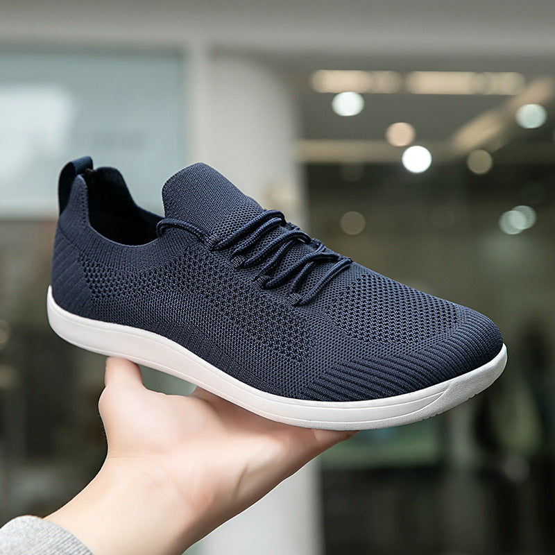 Hand holding a navy knit lace-up sneaker