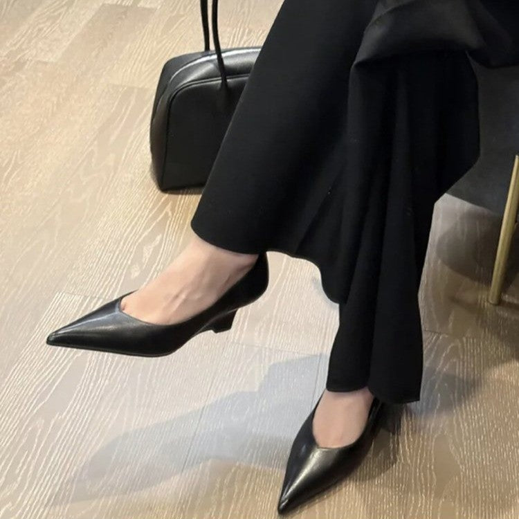 Woman wearing black pointed low-heel pumps with wide-leg trousers