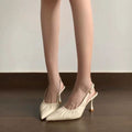 Front view of beige ruched pointed slingbacks worn on foot