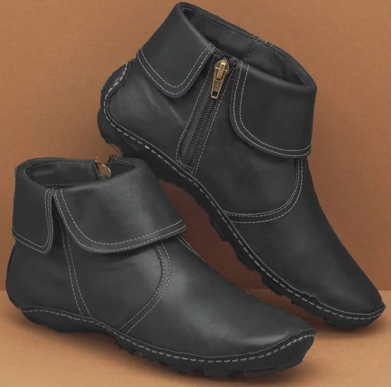 Pair of black fold-over ankle boots with contrast stitching and side zippers
