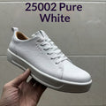 Hand holding a white pebbled leather low-top sneaker