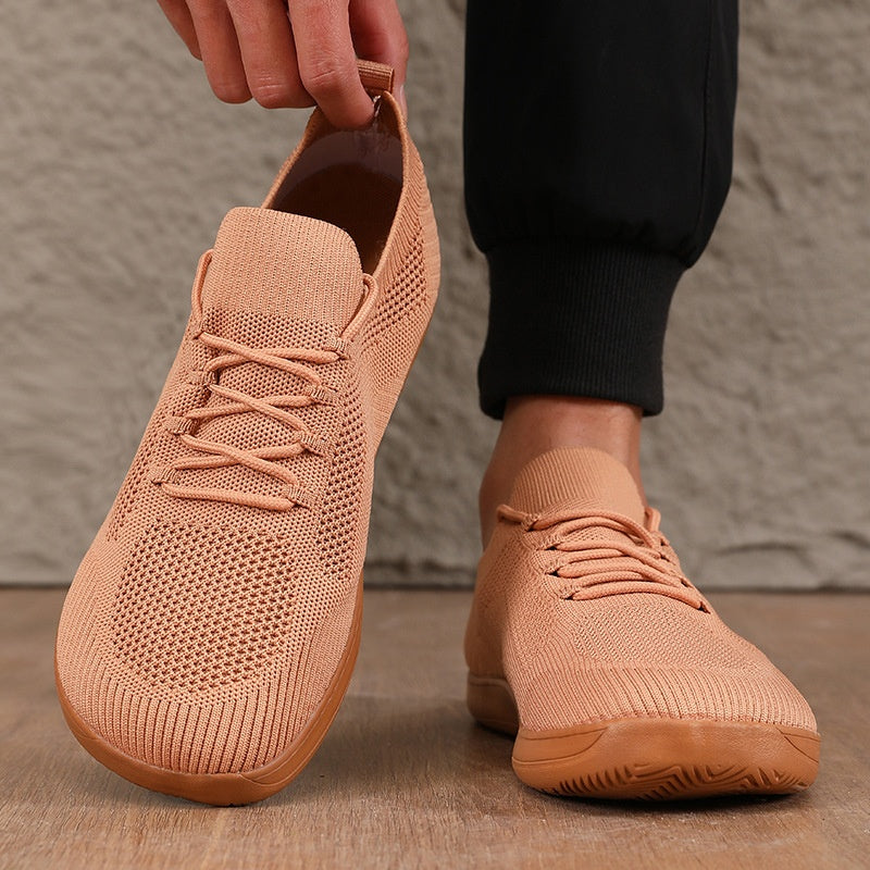 Man pulling on tan knit lace-up sneakers