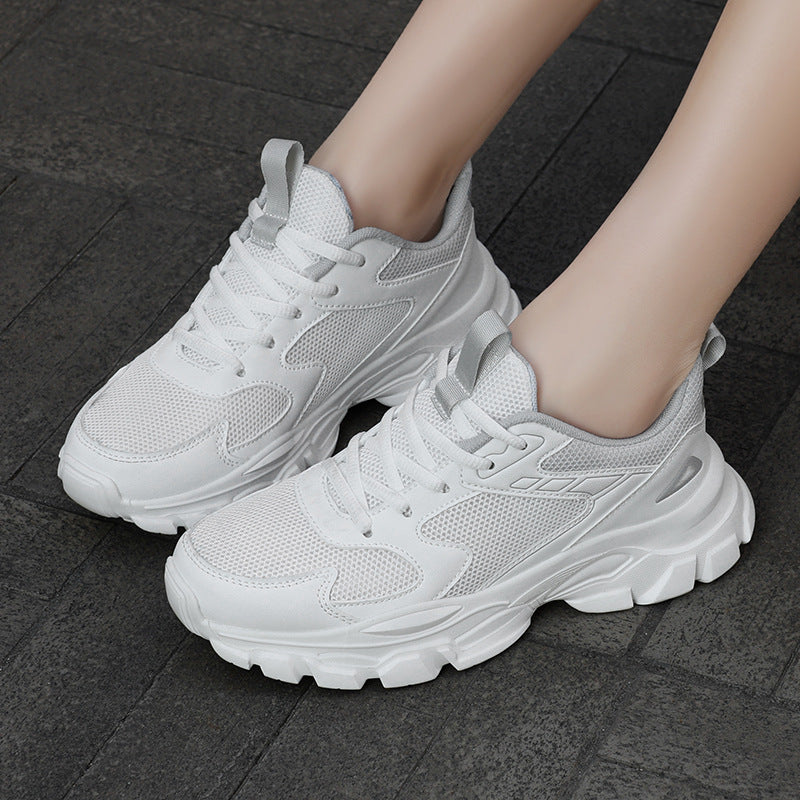 Close-up of white mesh trainers with sculpted chunky soles on feet