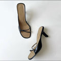 Pair of women's black strappy square-toe heeled sandals from above