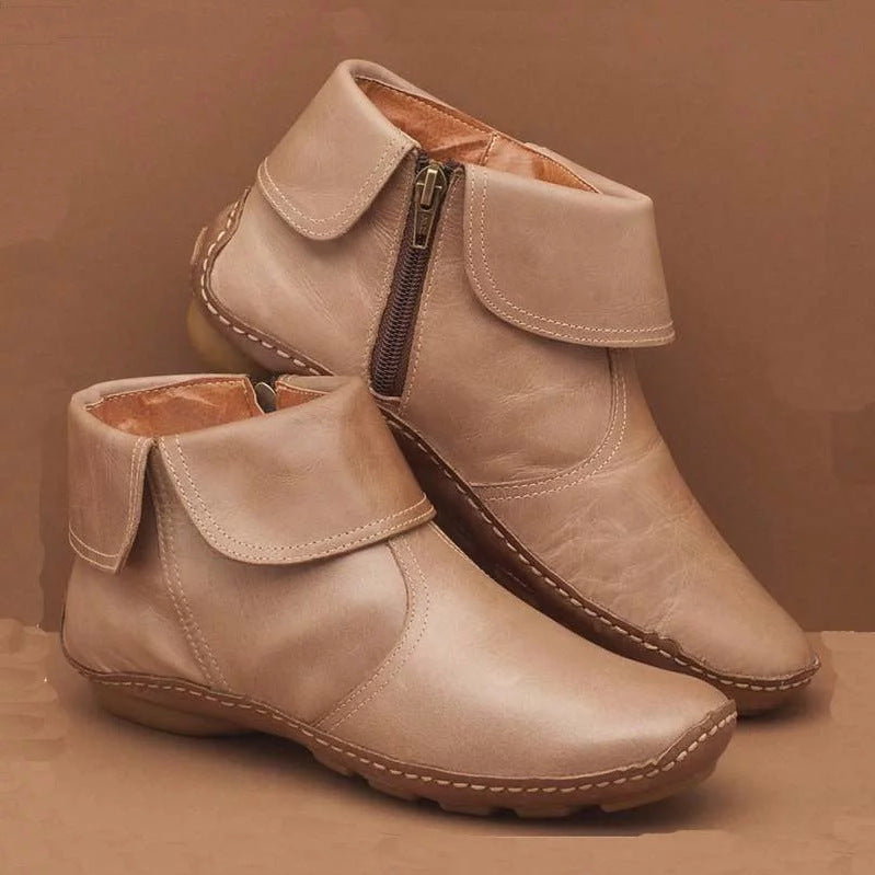 Pair of women's beige flat ankle boots with fold-over cuffs and side zippers