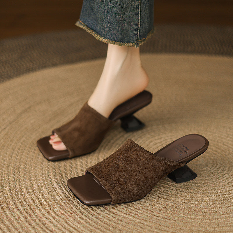 Brown suede mules with sculpted heels worn with jeans