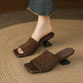 Brown suede mules with sculpted heels worn with jeans
