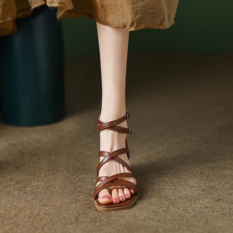 Brown crisscross strappy sandal with low block heel, front view on foot