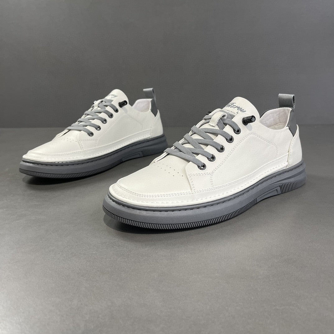 Pair of white leather low-top sneakers with gray laces and soles