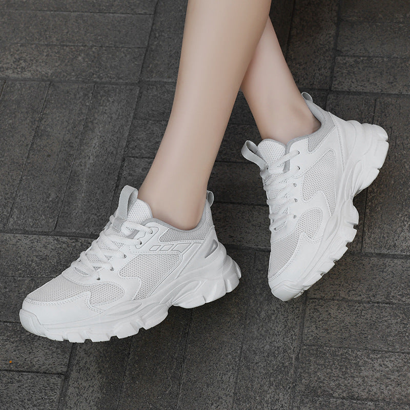 Woman wearing white chunky mesh lace-up trainers