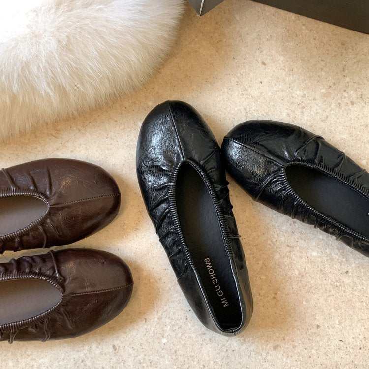 Brown and black pleated round-toe ballet flats, top view