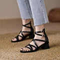 Black crisscross strappy block-heel sandals worn with cropped jeans