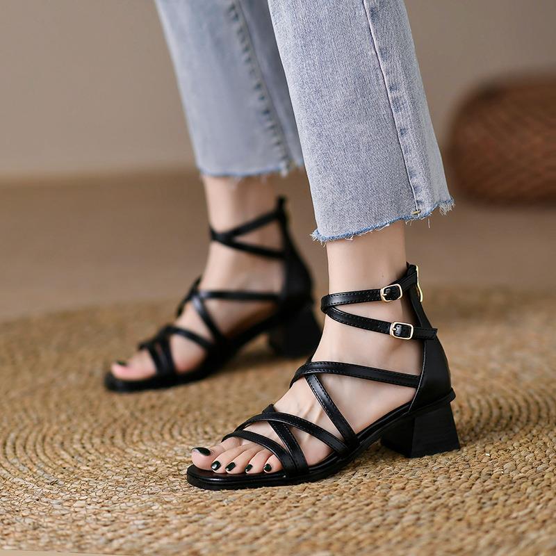 Black crisscross strappy block-heel sandals worn with cropped jeans