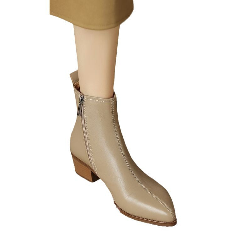 Beige pointed-toe ankle boot with side zip and low stacked heel, worn on foot