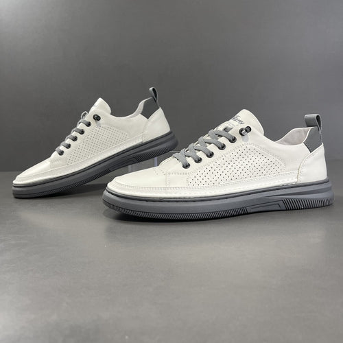 White perforated leather low-top sneaker beside a smooth white pair